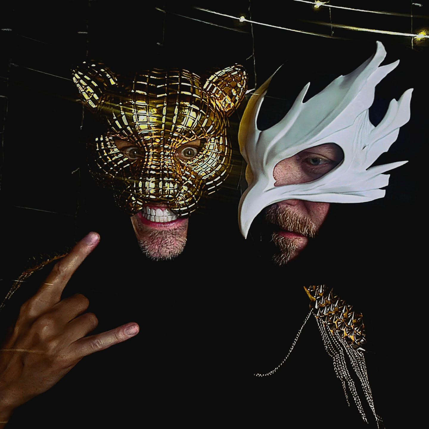 Tiger & Dove wearing their gold and white masks against a dark background
